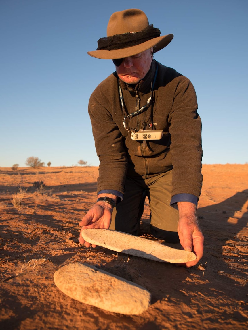 Mike Smith examines grinding stones found in the Simpson Desert.