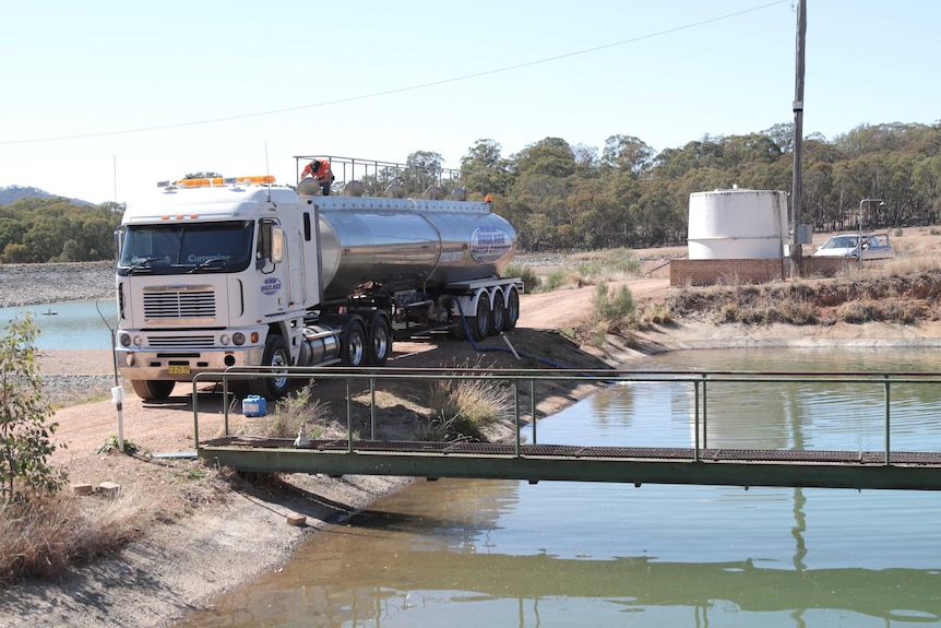 Un camion-citerne est stationné à côté d'un plan d'eau.