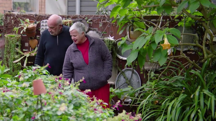 Judy and Andreas smile while looking at plants in their garden in inner-city Melbourne.