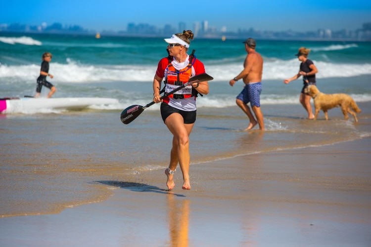 woman on beach with paddle