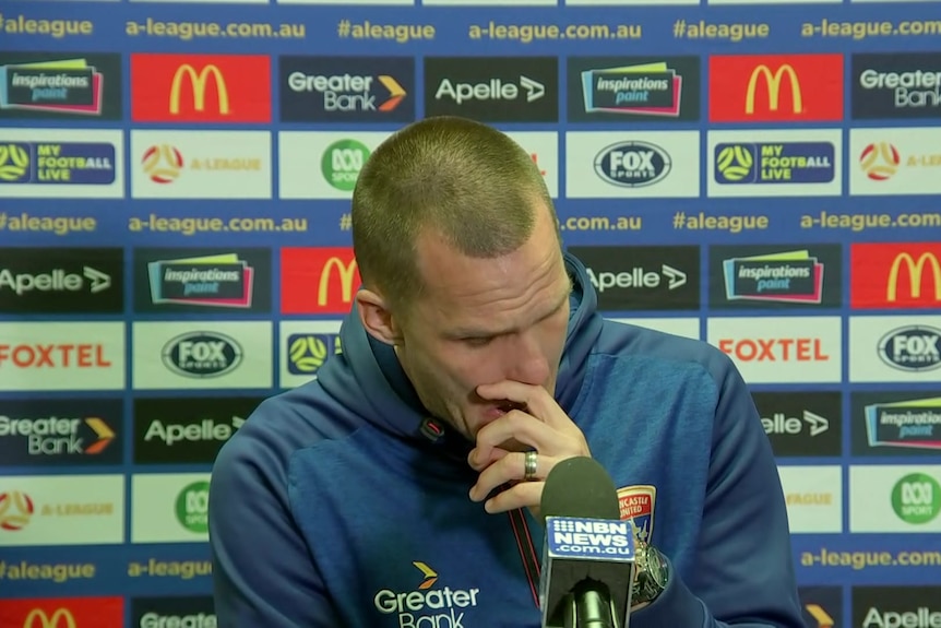 Nigel Boogard wipes his face in a press conference.