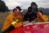Fire crews look at a map to plan firefighting activities.