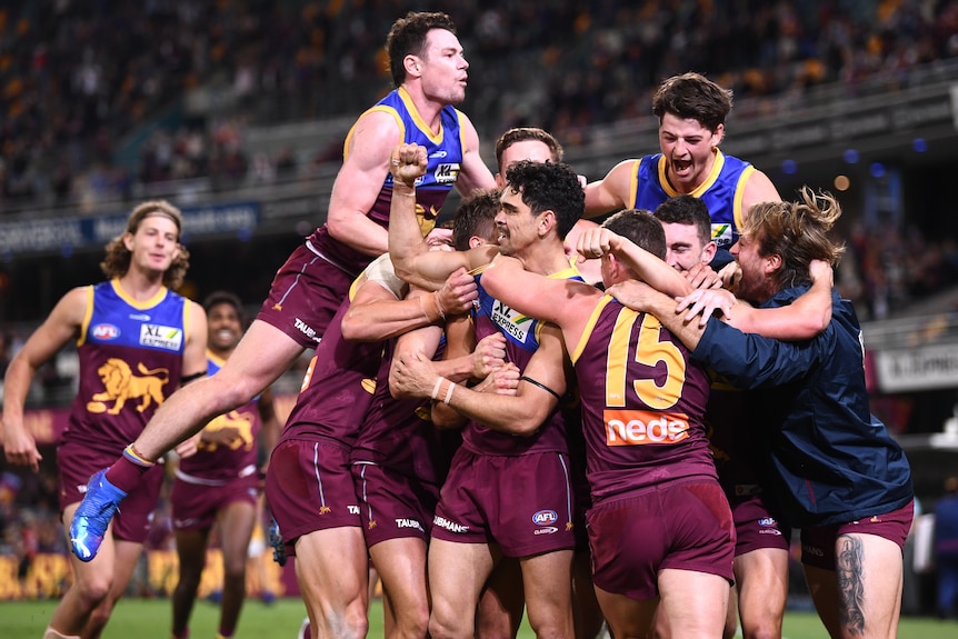 A group of Brisbane AFL players pile onto Charlie Cameron after he kicks a goal after the siren.