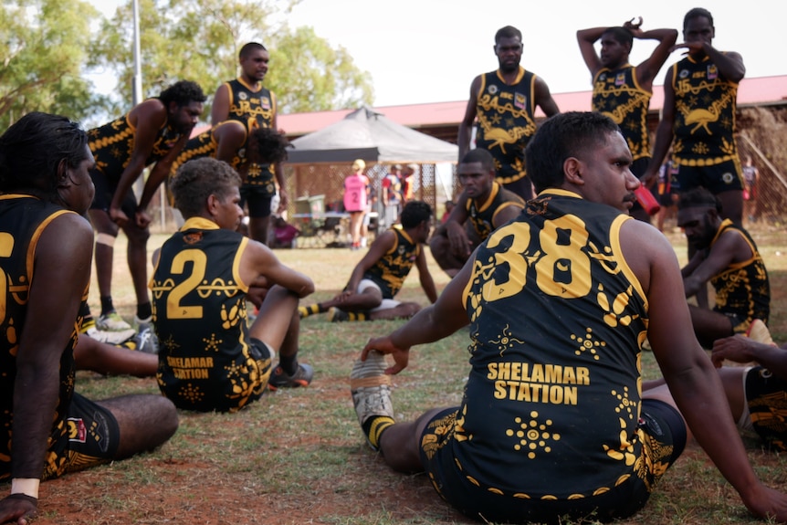 The Bidyadanga Emu men's team in a scrum during a football match in June 2022. 