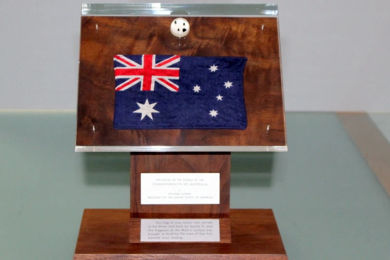 Presentation stand of moon rocks and flag in the collection of the National Archives of Australia.