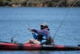 A paddler casts a line out to catch a fish.
