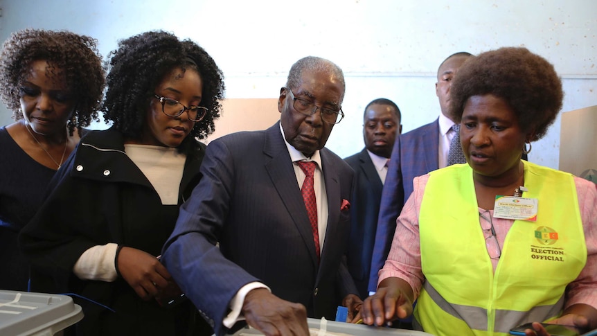 Former Zimbabwean president Robert Mugabe casts his vote at a polling station.