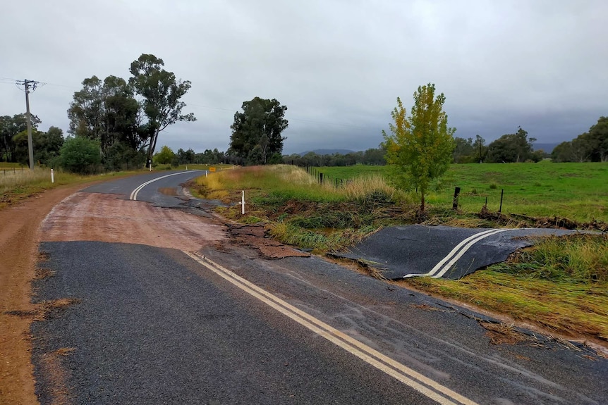 A severely damaged road after flooding.