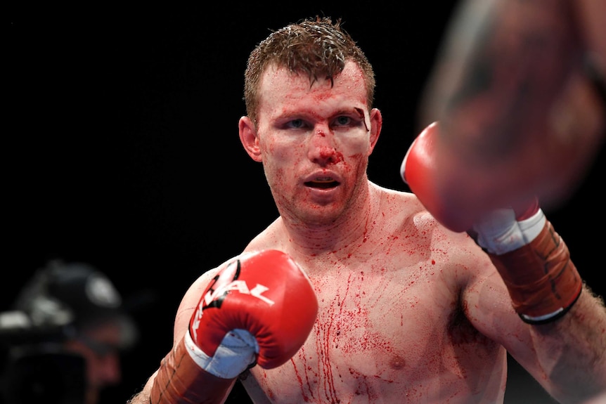 Jeff Horn holds a boxing stance with blood on his torso from a cut above his eye