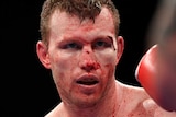 Jeff Horn holds a boxing stance with blood on his torso from a cut above his eye