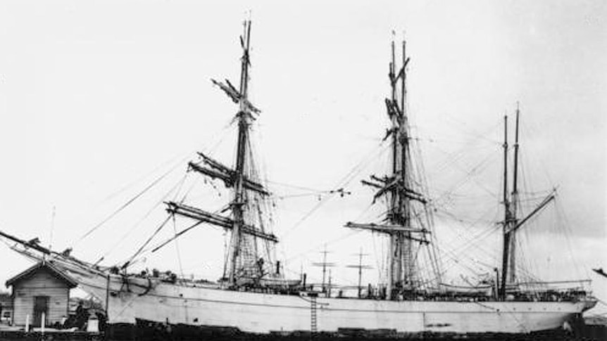 An old black and white photo of a three mast ship.