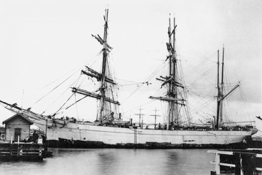 An old black and white photo of a three mast ship.