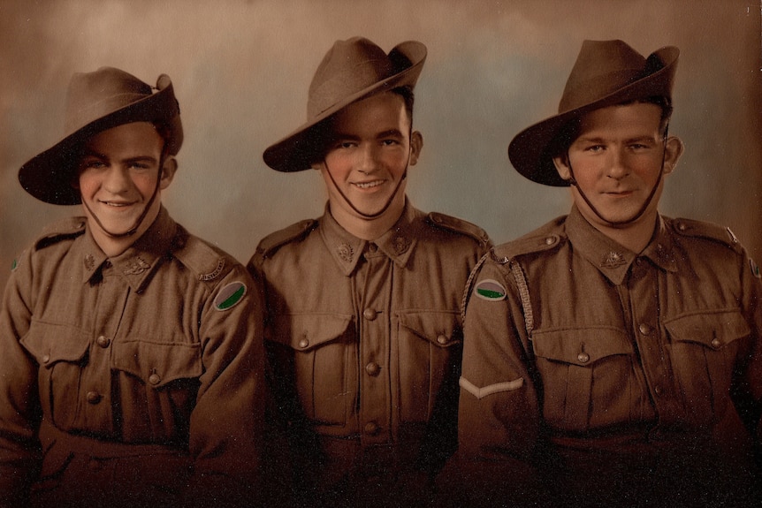 The Australian soldiers in a coloured photograph sit in a row. 
