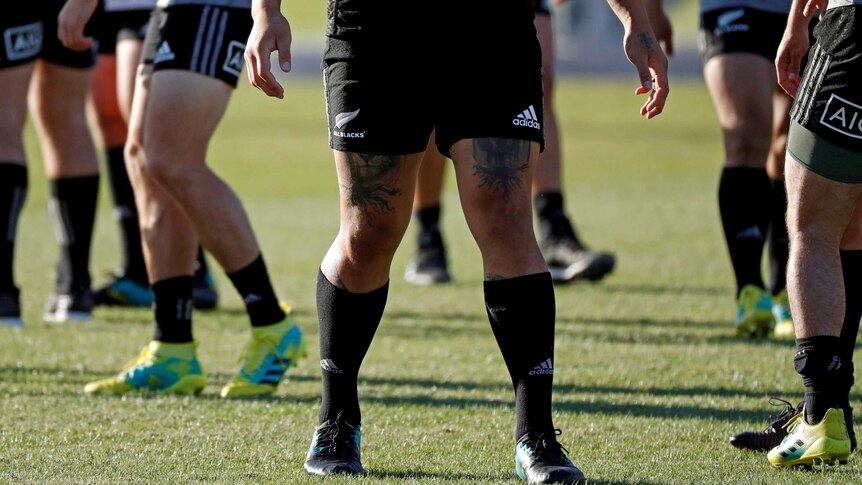 The tattooed limbs of a New Zealand's All Blacks player are seen during their training session.