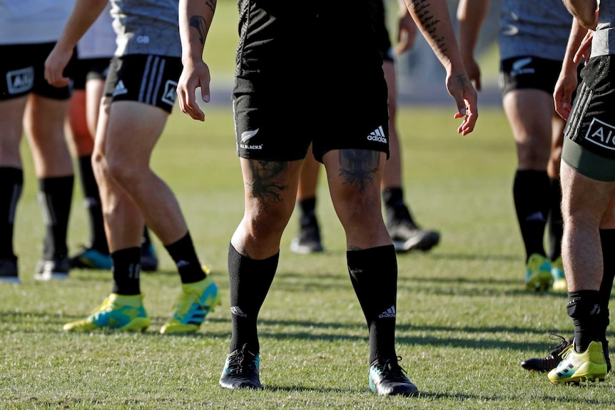 The tattooed limbs of a New Zealand's All Blacks player are seen during their training session.