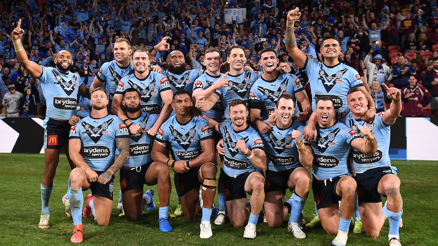 NSW Blues players pose for a celebratory photo on the field after winning the 2021 State of Origin series.