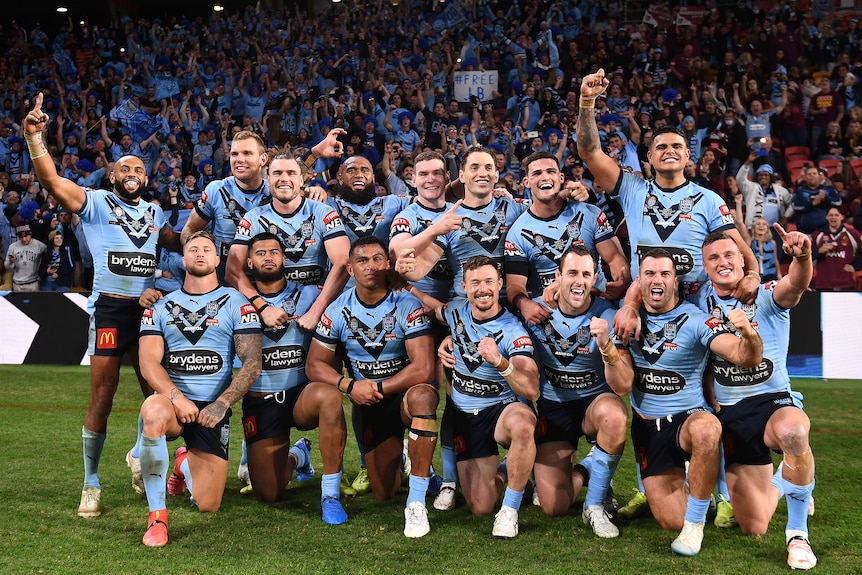 NSW Blues players pose for a celebratory photo on the field after winning the 2021 State of Origin series.