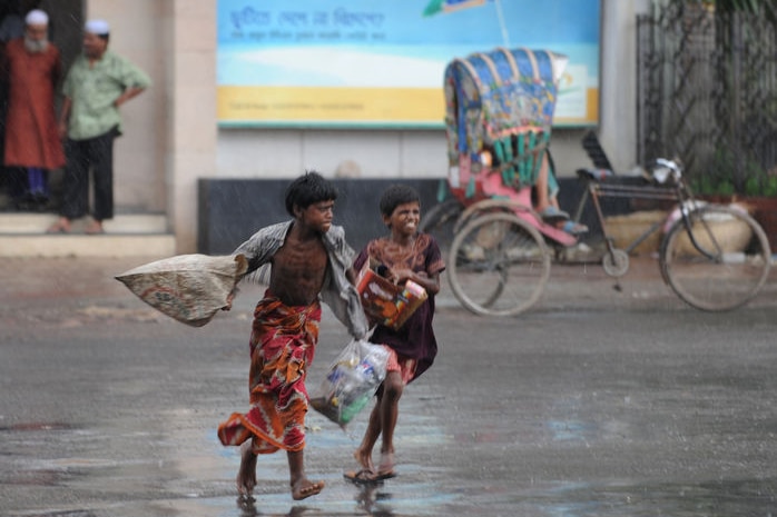 Two Bangladeshi children run for shelter from the rain in Dhaka (File image: AFP/Munir uz Zaman)