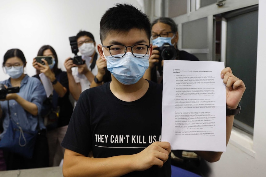Hong Kong pro-democracy activist Joshua Wong shows his disqualification notice during a press conference.