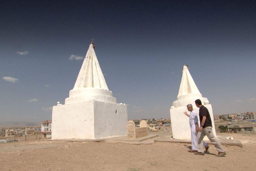 Matt Brown and Abdullah walk past a Yazidi shrine