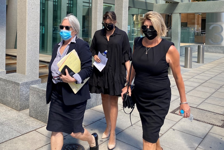 Three women wearing black outside a court building