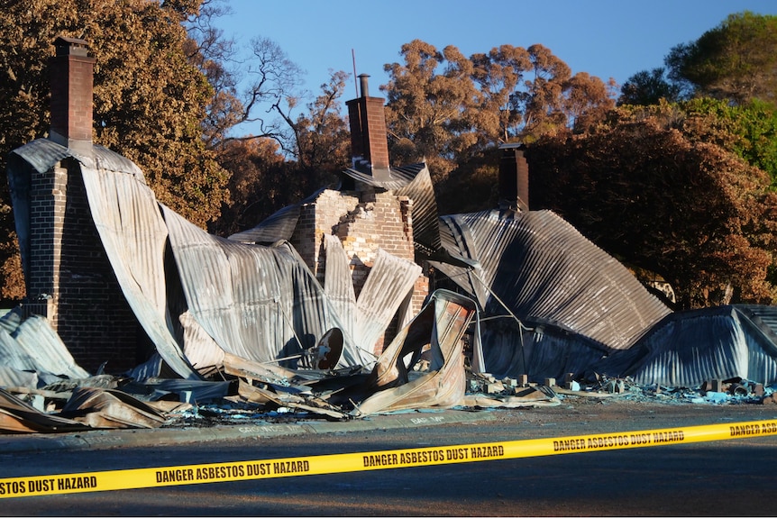 A fire crumpled building with yellow tape around it