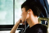 Young man listening to podcasts from his phone.