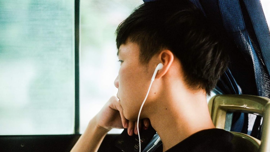 Young man listening to podcasts from his phone.