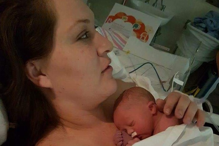 Mum Claire in hospital holding her newborn