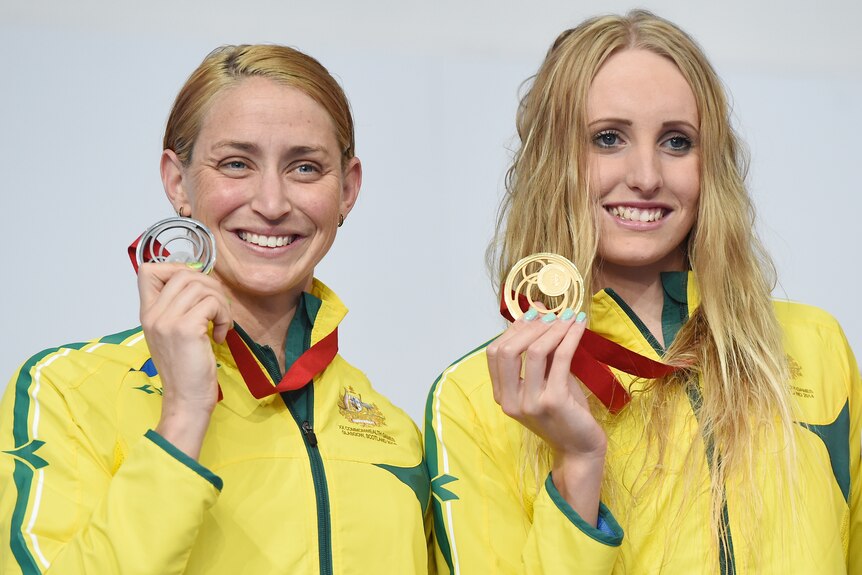 Two Australian female swimmers show off their 2014 Commonwealth Games medals.