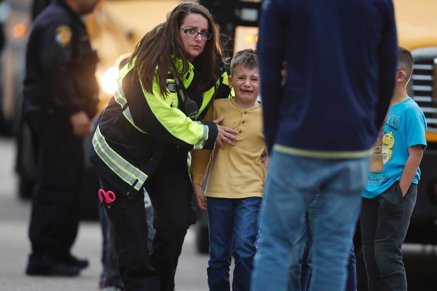 Officials guide children after a school shooting in Colorado.