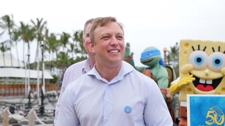 Steven Miles stands in front of children's characters at Sea World.