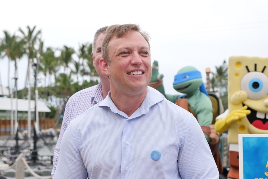 Steven Miles stands in front of children's characters at Sea World.