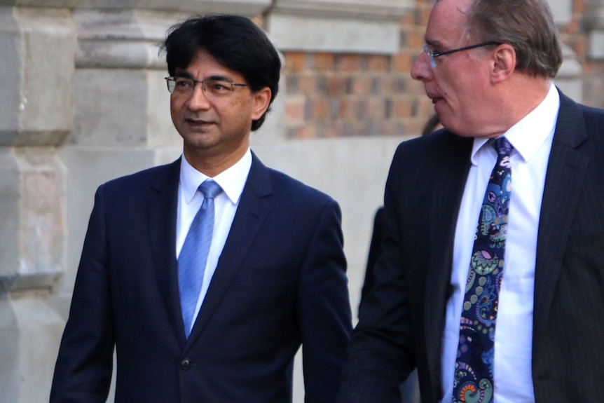 Mid-shot of Lloyd Rayney with Martin Bennett outside a court building.