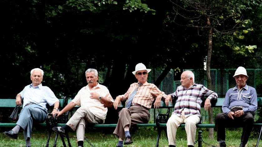 Elderly men sit on a park bench