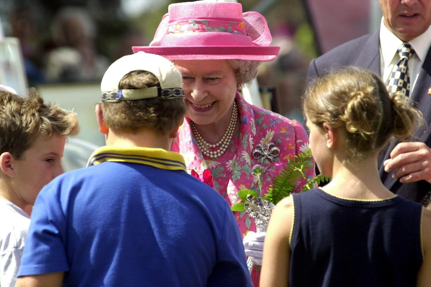 The queen smiles at school choldren