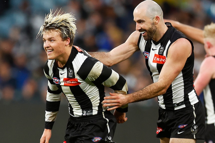Jack Ginnivan smiles as Steele Sidebottom pats him on the back