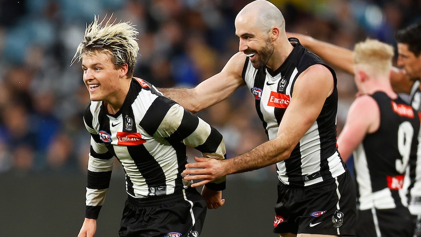 Jack Ginnivan smiles as Steele Sidebottom pats him on the back