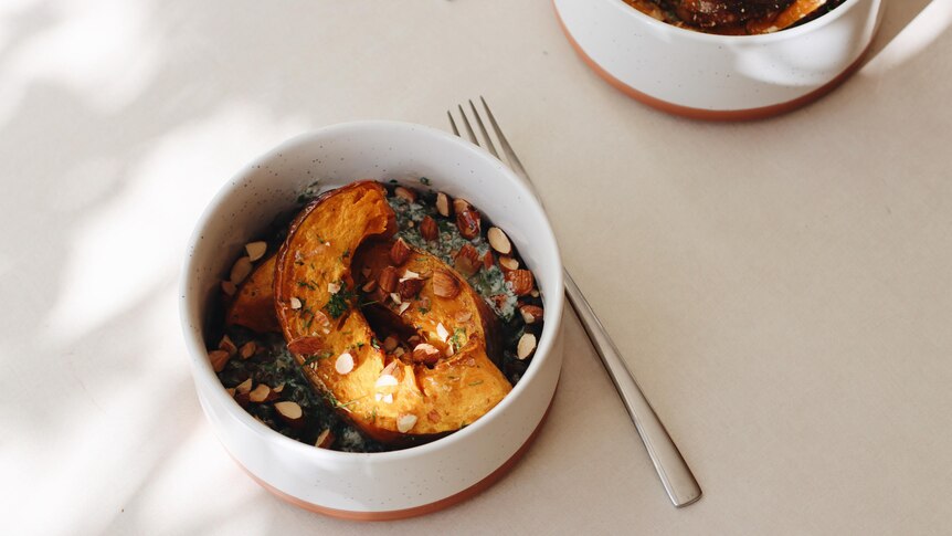 Bird's eye view of pumpkin and lentils served in a bowl with a spoon.