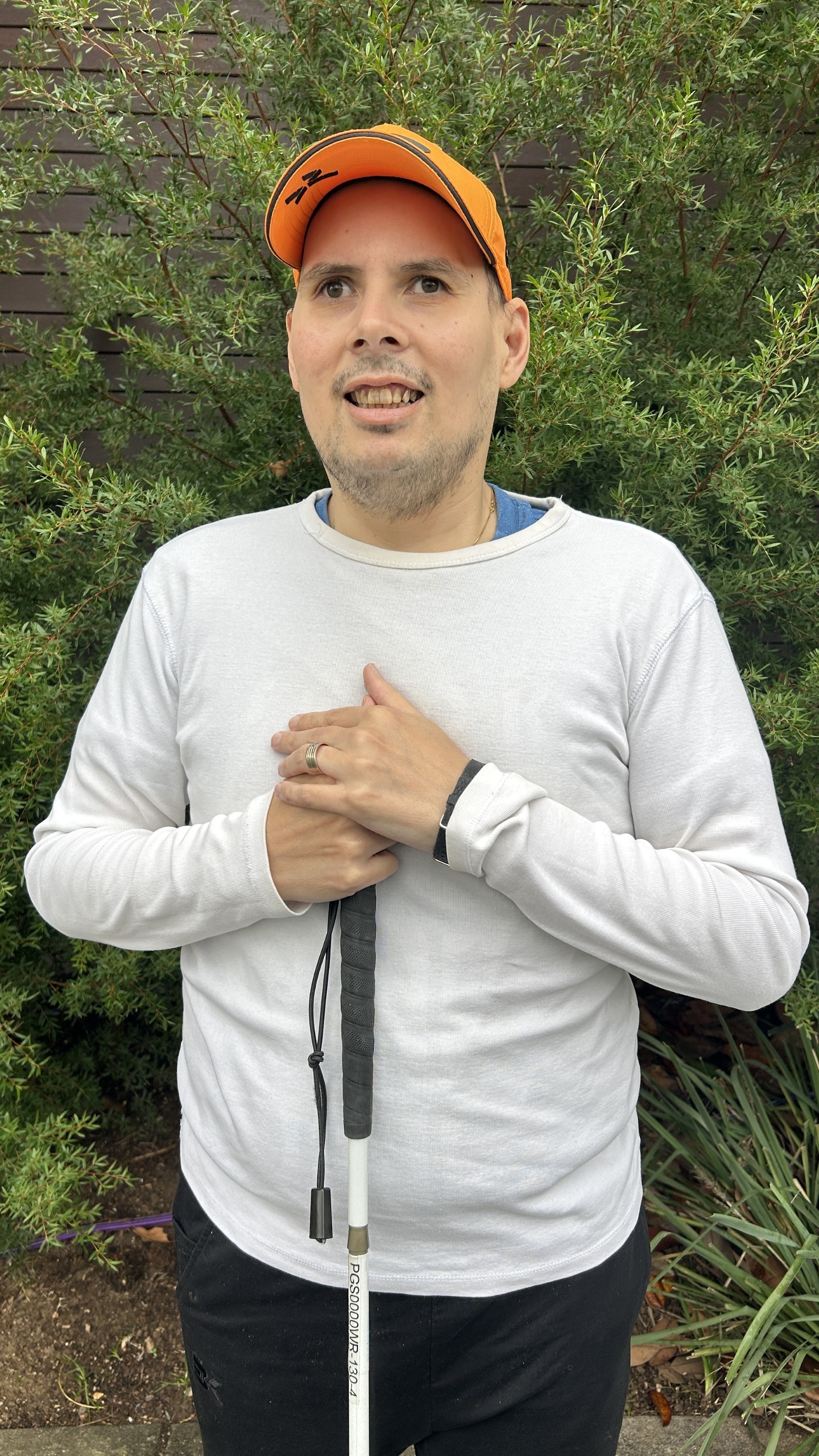 A man holds a cane used for navigating his environment