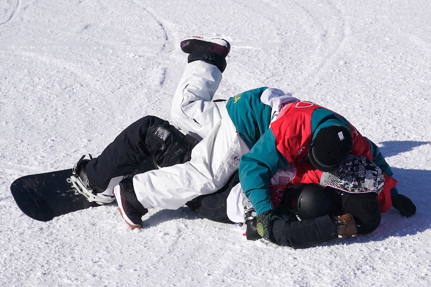 An Australian snowboarder piles on top of two other competitors after all three clinched medals at the Winter Olympics.