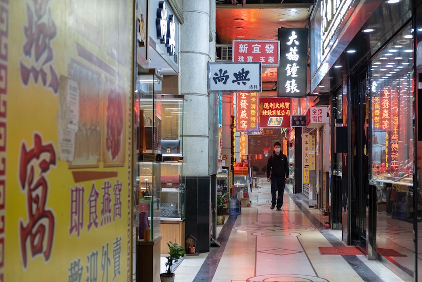 A man walks through the old shops.