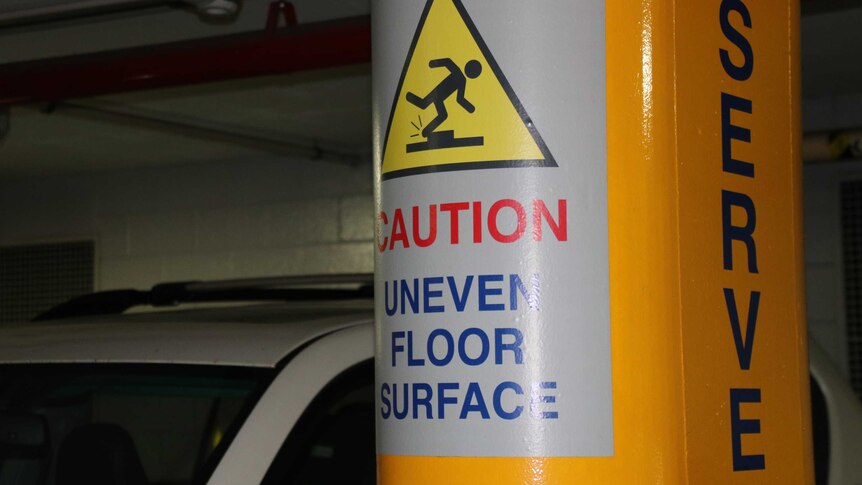 A sign warning of an uneven floor surface in the Perth Convention Centre car park.