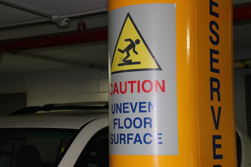 A sign warning of an uneven floor surface in the Perth Convention Centre car park.