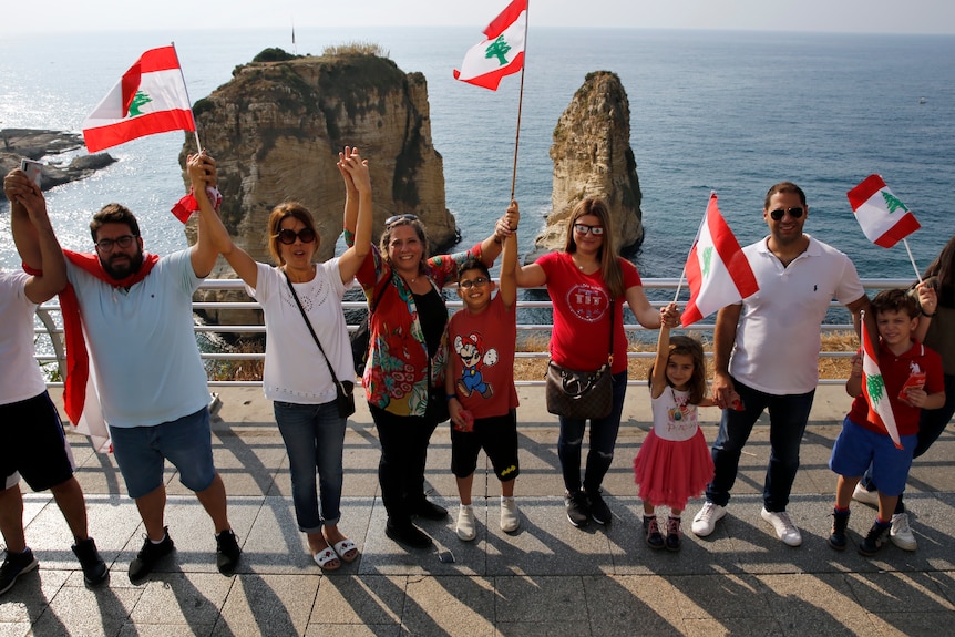 Anti-government protesters form a human chain as a symbol of unity in front of the Mediterranean.