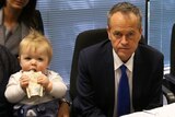 Baby sips its drink next to Bill Shorten, looking straight on at a Marriage equality round table discussion