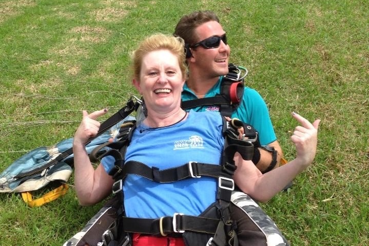 Jenni Wines smiles on the ground after landing from a skydive to depict taking an adult gap year.