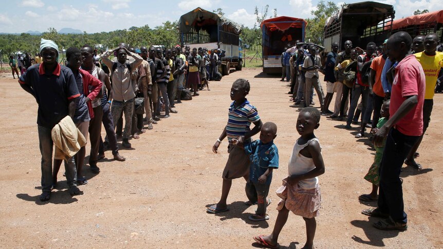 People line up for supplies from aid trucks