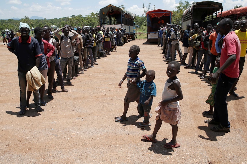 People line up for supplies from aid trucks