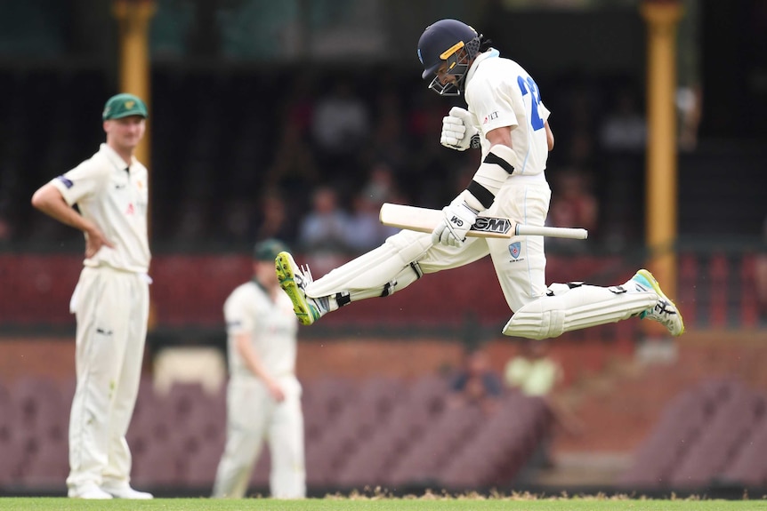 Jason Sangha jumps in the air as he celebrates scoring a century for New South Wales in the Sheffield Shield.